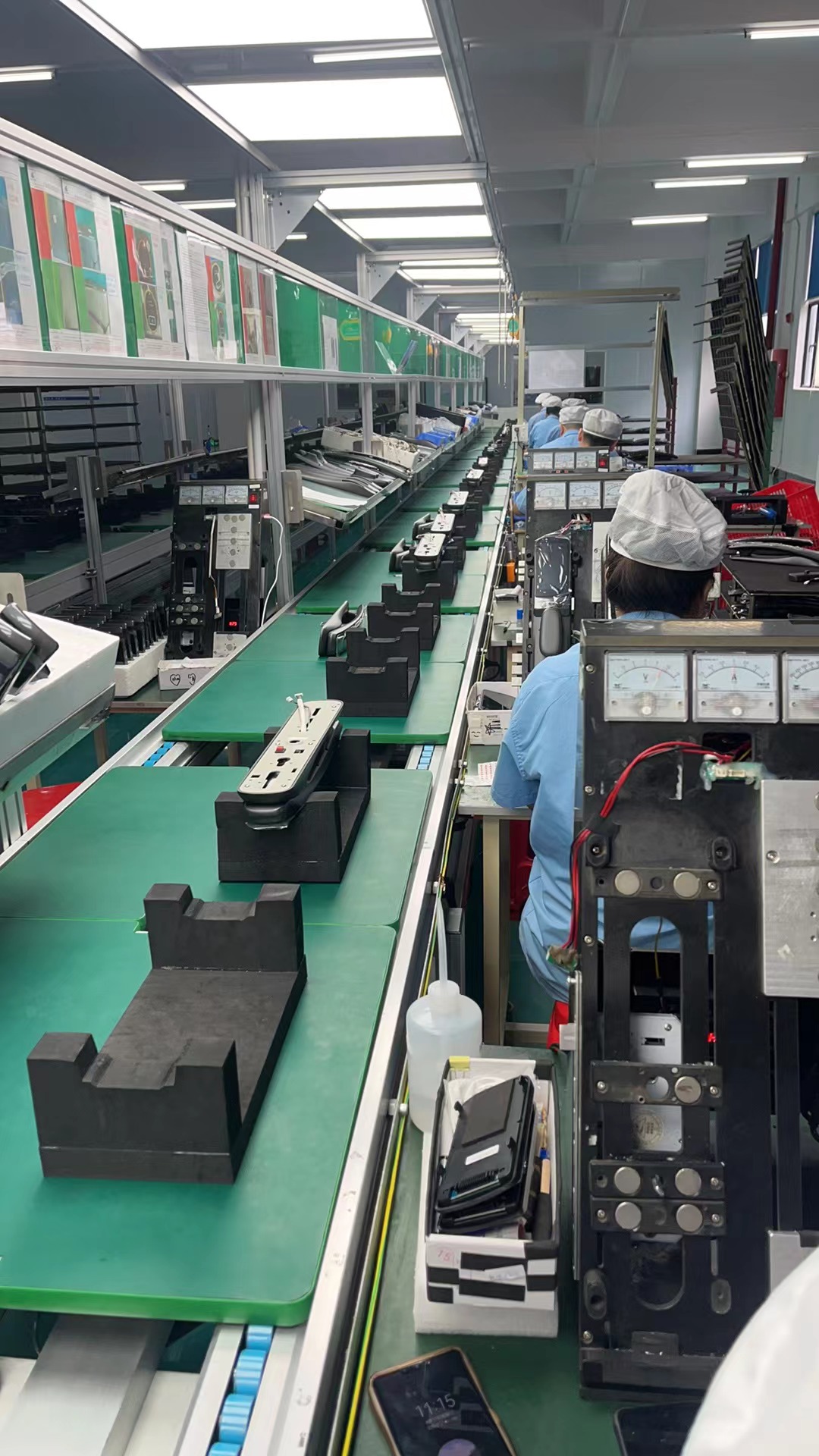 Forty two year old female operations manager in industrial setting, wearing safety vest, inspecting manufacturing equipment